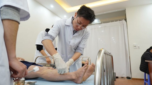 Thạc sĩ, bác sĩ Ngô Quang Hùng đang thực hiện cấy chỉ Catgut điều trị cho bệnh nhân xương khớp